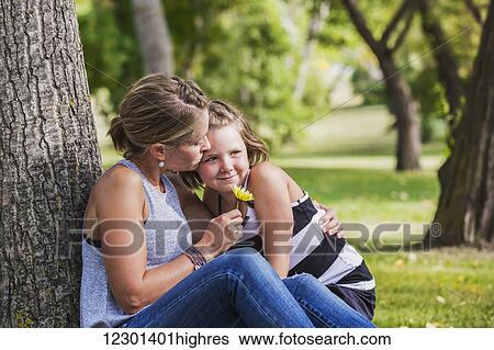 Mother getting a flower from her daughter while spending quality time at a park during a family outing; Edmonton, Alberta, Canada View Large Photo Image Stock Photograph - Mother getting a flower from her daughter while spending quality time at a park during a family outing; Edmonton, Alberta, Canada. Fotosearch