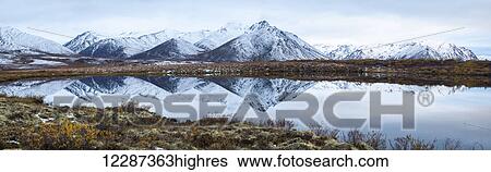 Stock Photograph - Mount Adney reflected in a pond along the Dempster Highway in the northern Yukon; Yukon, Canada. Fotosearch