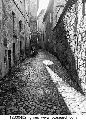 Narrow cobblestone alley between buildings; Orvieto, Umbria, Italy View Large Photo Image Stock Photograph - Narrow cobblestone alley between buildings; Orvieto, Umbria, Italy. Fotosearch