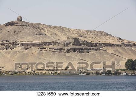 Stock Image - Nile River and Tombs of the Nobles in the background; Aswan, Egypt. Fotosearch