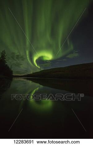 Stock Image - Northern Lights (aurora borealis) over the Pelly River; Ross River, Yukon, Canada. Fotosearch