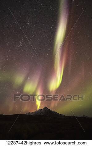 Stock Photograph - Northern Lights (aurora borealis) over top of Angelcomb Peak, Dempster Highway; Yukon, Canada. Fotosearch