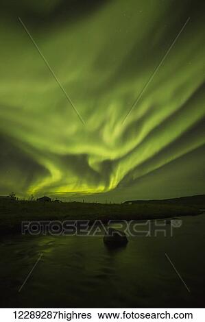 Stock Photograph - Northern lights dancing over the Langanes Peninsula and the Atlantic Ocean; Iceland. Fotosearch