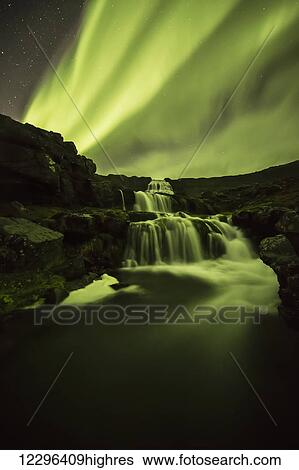 Northern Lights, or Aurora Borealis, glowing over waterfalls and a stream; Iceland View Large Photo Image Stock Photograph - Northern Lights, or Aurora Borealis, glowing over waterfalls and a stream; Iceland. Fotosearch