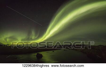 Stock Photograph - Northern lights over a river and farm in Northeast Iceland; Iceland. Fotosearch