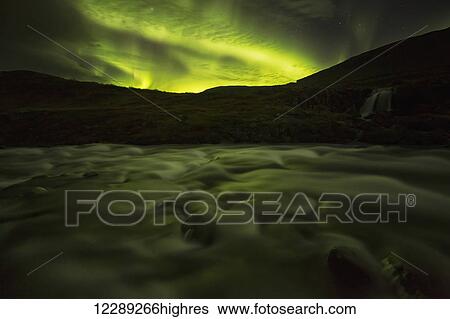 Stock Photograph - Northern lights over Dynjandi in the Westfjord region of Iceland, Dynjandi is a series of seven waterfalls; Westfjords, Iceland. Fotosearch