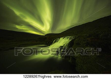 Stock Photograph - Northern lights over Dynjandi in the Westfjord region of Iceland, Dynjandi is a series of seven waterfalls; Westfjords, Iceland. Fotosearch