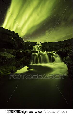 Stock Photograph - Northern lights over Dynjandi in the Westfjord region of Iceland, Dynjandi is a series of seven waterfalls; Westfjords, Iceland. Fotosearch