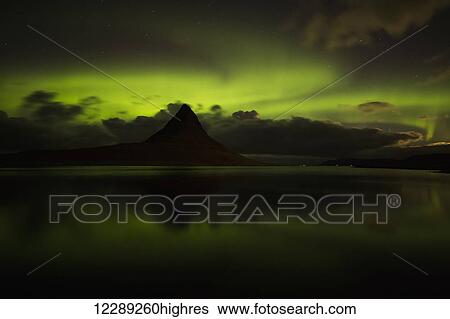 Stock Photograph - Northern lights over top of Kirkjufell, the most photographed mountain in Iceland; Iceland. Fotosearch