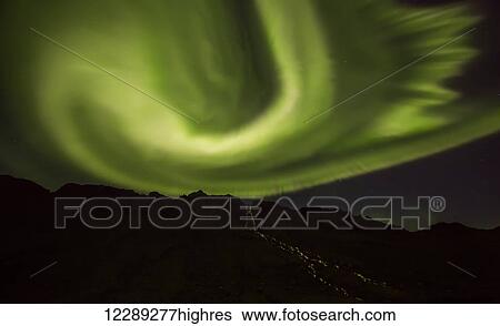 Stock Photograph - Northern lights over top of the town known as Djupavik along the Strandir Coast; Djupavik, Iceland. Fotosearch