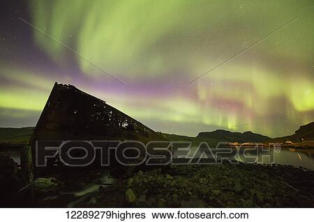 Northern lights over top of the town known as Djupavik along the Strandir Coast, here they are dancing above the old herring factory and shipwreck; Djupavik, Iceland View Large Photo Image Stock Photograph - Northern lights over top of the town known as Djupavik along the Strandir Coast, here they are dancing above the old herring factory and shipwreck; Djupavik, Iceland. Fotosearch