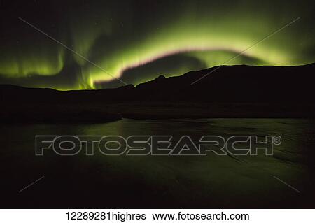 Stock Photograph - Northern lights over top of the town known as Djupavik along the Strandir Coast; Djupavik, Iceland. Fotosearch