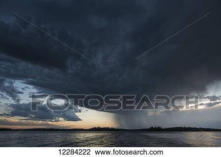 Ominous dark storm cloud and rain over a lake; Ontario, Canada View Large Photo Image Stock Image - Ominous dark storm cloud and rain over a lake; Ontario, Canada. Fotosearch