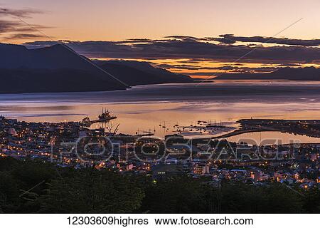 Stock Photograph - Orange and purple pre-dawn light over Ushuaia; Ushuaia, Antarctica. Fotosearch