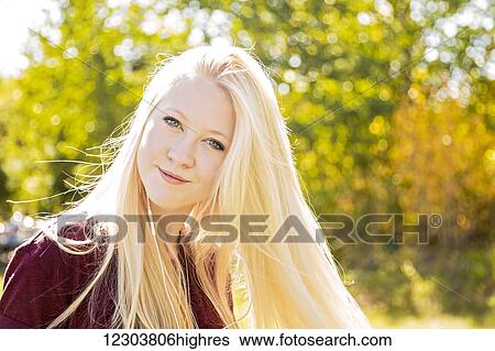 Outdoor portrait of a beautiful young woman with long blond hair in a city park in autumn; Edmonton, Alberta, Canada View Large Photo Image Stock Photograph - Outdoor portrait of a beautiful young woman with long blond hair in a city park in autumn; Edmonton, Alberta, Canada. Fotosearch