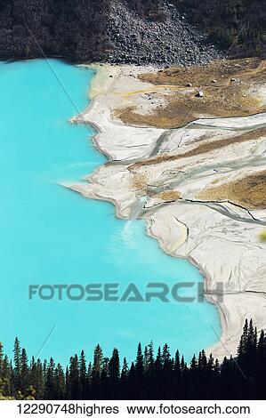 Stock Photograph - Overlooking high above an intense blue coloured lake with delta shoreline, Banff National Park; Alberta, Canada. Fotosearch