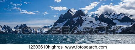 Stock Photograph - Panorama of mountains at entrance to fjord; Antarctica. Fotosearch