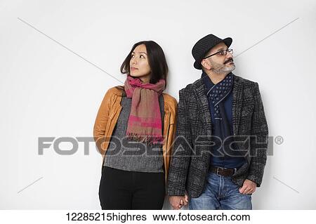 Persian man and Tibetan woman holding hands and leaning against a wall facing away from each other; Toronto, Ontario, Canada View Large Photo Image Stock Photograph - Persian man and Tibetan woman holding hands and leaning against a wall facing away from each other; Toronto, Ontario, Canada. Fotosearch