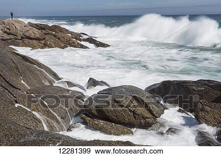 Stock Photo - Person taking photos of large waves along the South coast of South Africa in Namakwaland National Park; South Africa. Fotosearch