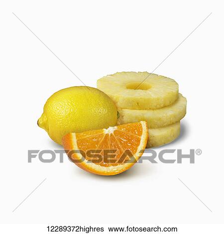 Stock Photograph - Pineapple slices, orange wedge and a lemon on a white background; Toronto, Ontario, Canada. Fotosearch