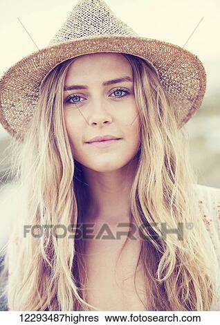 Stock Photograph - Portrait of a beautiful young girl in a hat. Warm vintage fashion color tones.. Fotosearch