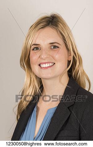 Stock Photograph - Portrait of a business woman with long blond hair, blue blouse and jacket; England. Fotosearch