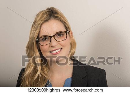 Stock Photograph - Portrait of a business woman with long blond hair, blue blouse and jacket; England. Fotosearch