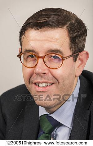 Stock Photograph - Portrait of a businessman wearing eyeglasses and a suit and tie; England. Fotosearch