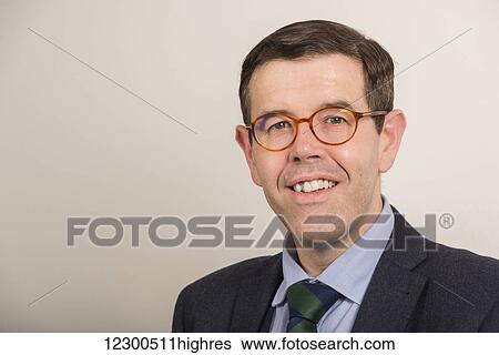 Stock Photograph - Portrait of a businessman wearing eyeglasses and a suit and tie; England. Fotosearch