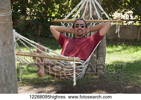 Stock Photograph - Portrait of a man relaxing in a hammock; Turkey. Fotosearch