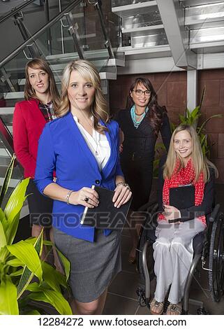 Portrait of a professional business woman with her team in the lobby of an office, one of which is a paraplegic in a wheelchair; St. Albert, Alberta, Canada View Large Photo Image Stock Image - Portrait of a professional business woman with her team in the lobby of an office, one of which is a paraplegic in a wheelchair; St. Albert, Alberta, Canada. Fotosearch