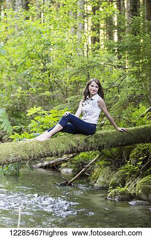 Portrait of a teenage girl sitting on a moss covered log over a stream; Chilliwack, British Columbia, Canada View Large Photo Image Stock Photograph - Portrait of a teenage girl sitting on a moss covered log over a stream; Chilliwack, British Columbia, Canada. Fotosearch