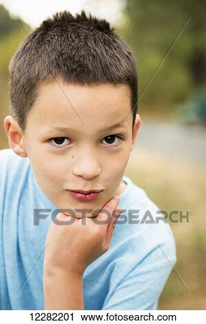 Portrait of a young boy with his chin resting on his hand; Chilliwack, British Columbia, Canada View Large Photo Image Stock Image - Portrait of a young boy with his chin resting on his hand; Chilliwack, British Columbia, Canada. Fotosearch