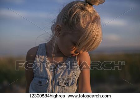 Stock Photograph - Portrait of a young girl on a beach at sunset; Surrey, British Columbia, Canada. Fotosearch