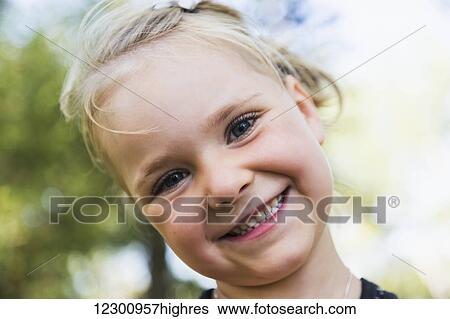 Stock Photograph - Portrait of a young girl with a big smile and blond hair; Edmonton, Alberta, Canada. Fotosearch