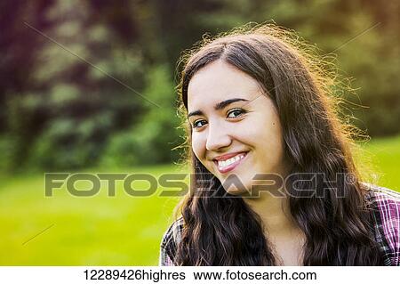 Stock Photograph - Portrait of a young woman outdoors at sunset; Sherwood Park, Alberta, Canada. Fotosearch