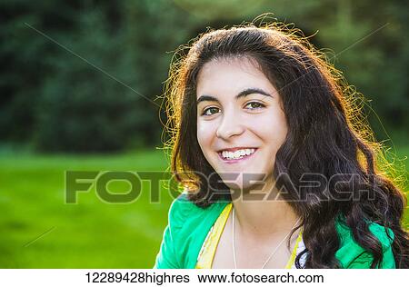 Stock Photograph - Portrait of a young woman outdoors at sunset; Sherwood Park, Alberta, Canada. Fotosearch