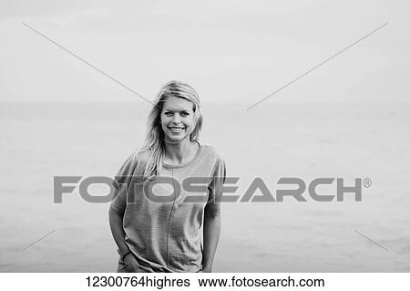 Portrait of a young woman with long blond hair at the ocean; Hastings, Sussex, England View Large Photo Image Stock Photograph - Portrait of a young woman with long blond hair at the ocean; Hastings, Sussex, England. Fotosearch