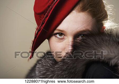 Portrait of a young woman with red hair in a red hat and black fur; Caldecott, England View Large Photo Image Stock Photograph - Portrait of a young woman with red hair in a red hat and black fur; Caldecott, England. Fotosearch