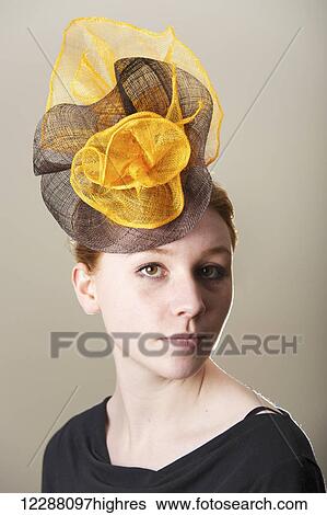 Portrait of a young woman with red hair wearing a orange and black mesh hat; Caldecott, England View Large Photo Image Stock Photograph - Portrait of a young woman with red hair wearing a orange and black mesh hat; Caldecott, England. Fotosearch