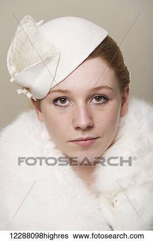 Portrait of a young woman with red hair wearing a white hat and white fur coat; Caldecott, England View Large Photo Image Stock Photograph - Portrait of a young woman with red hair wearing a white hat and white fur coat; Caldecott, England. Fotosearch