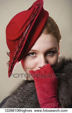Portrait of a young woman with red hair wearing a red hat, red suede gloves and grey fur coat; Caldecott, England View Large Photo Image Stock Photograph - Portrait of a young woman with red hair wearing a red hat, red suede gloves and grey fur coat; Caldecott, England. Fotosearch