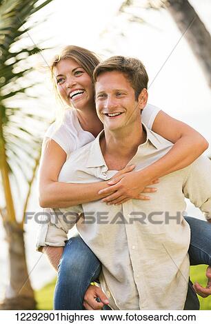 Stock Photograph - Portrait of happy smiling young couple outdoors. Fotosearch