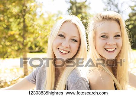 Portrait of two sisters in a city park in autumn; Edmonton, Alberta, Canada View Large Photo Image Stock Photograph - Portrait of two sisters in a city park in autumn; Edmonton, Alberta, Canada. Fotosearch