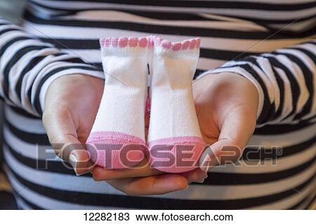 Pregnant woman holding pink and white baby socks; Langley, British Columbia, Canada View Large Photo Image Stock Image - Pregnant woman holding pink and white baby socks; Langley, British Columbia, Canada. Fotosearch