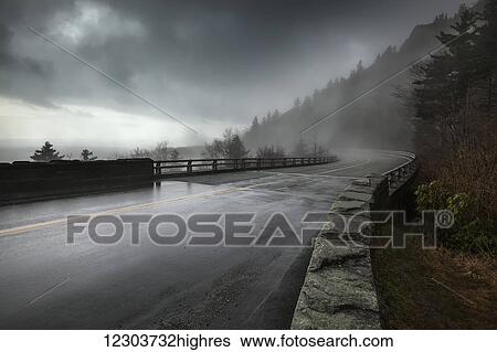Rain on a wet bridge of North Carolinas Linn Cove Viaduct on the Blue Ridge Parkway with moody, low-hanging storm clouds and mist; North Carolina, United States of America View Large Photo Image Stock Photograph - Rain on a wet bridge of North Carolinas Linn Cove Viaduct on the Blue Ridge Parkway with moody, low-hanging storm clouds and mist; North Carolina, United States of America. Fotosearch
