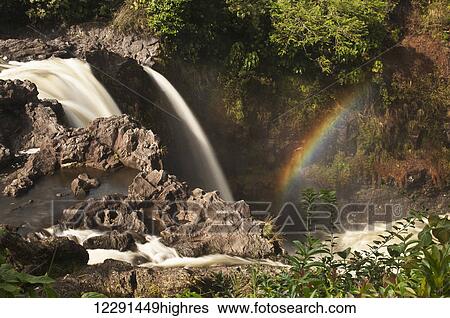 Stock Photograph - Rainbow Falls with a rainbow; Hilo, Island of Hawaii, Hawaii, United States of America. Fotosearch