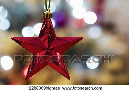 Stock Photograph - Red Christmas tree star with bokeh lights; London, England. Fotosearch