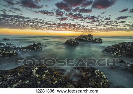 Stock Photograph - Red clouds of sunset over the ocean along the coast of South Africa near Hondeklip Bay; Namakwa, South Africa. Fotosearch