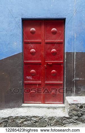 Red metal door on a wall painted brown and blue; San Miguel de Allende, Guanajuato, Mexico View Large Photo Image Stock Photograph - Red metal door on a wall painted brown and blue; San Miguel de Allende, Guanajuato, Mexico. Fotosearch